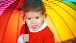 barn under regnbuefarvet paraply 