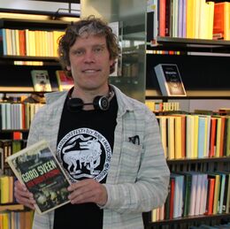 Foto af Thomas Damholt, der viser Gard Sveens Den sidste pilgrim frem på Næstved Bibliotek