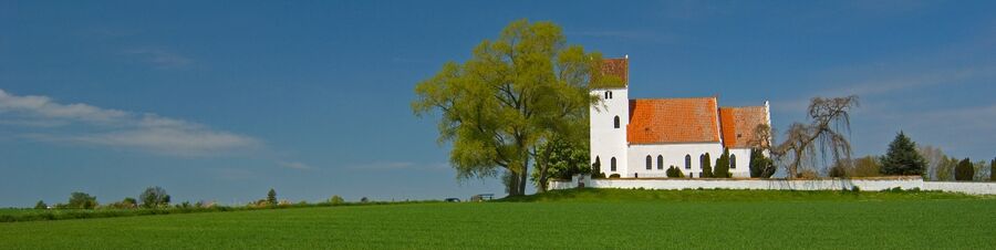 Billede af kirke i det danske landskab