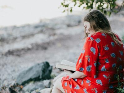 Naturdigte: en kvinde læser ved en strand. Fotokreditering: Priscilla Du Prezz for Unsplash.