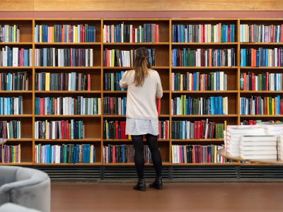 En person kigger på bøger på biblioteket. Fotokreditering: Christopher Egeberg for Centralbiblioteket.